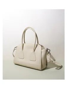 Vue détaillée du sac porté épaule Boston en cuir blanc cassé avec poignées et sangle.