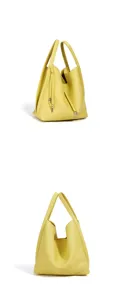 Detail view of the yellow leather bucket bag showcasing premium texture and handles.
