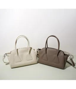 Vue détaillée des sacs bandoulière Boston en cuir véritable crème et marron au design unique.