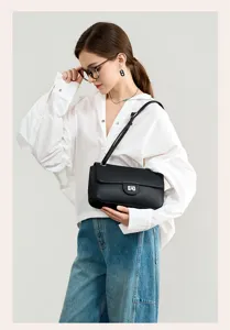 Closeup scene view of premium black leather shoulder bag styled with white shirt and jeans.