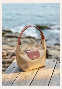 Nylon commuter dumpling bag with brown leather flap and top handle for casual daily use