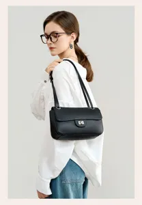 Close-up detail of genuine leather shoulder bag with chic turn lock and double straps.