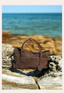 Detailed view of brown suede shoulder bag showing texture and design features for women.