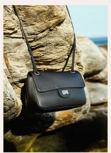 Classic black leather crossbody bag featuring pebbled texture and metal turn-lock closure.