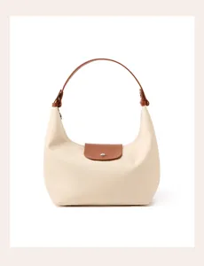 Nylon hobo dumpling bag detailed view, showing smooth beige fabric and brown leather handle.