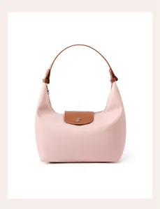 Chic pink nylon dumpling shoulder bag with brown leather flap handle, elegant commuter underarm style.