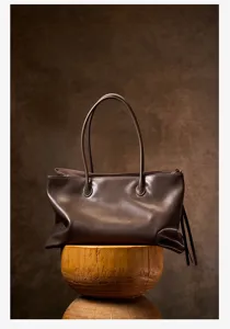 Detail shot of retro brown leather shoulder tote bag, minimalist style large capacity handbag.