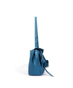 Blue leather shoulder bag side view detail showing sleek commuting style and premium cowhide texture.