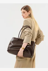 Detail shot of minimalist dark brown leather tote bag, elegant style, soft texture, large capacity.
