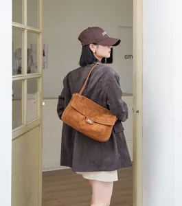Braune Wildleder Umhängetasche Detailansicht, lässige Achseltasche mit Metall Drehverschluss.