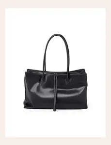 Black leather tote bag detail, minimalist shoulder bag handle and premium texture design.