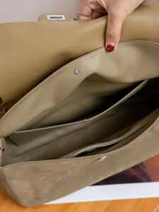 Detailansicht der Wildleder-Umhängetasche mit Innenfächern, Taschen und Futter.