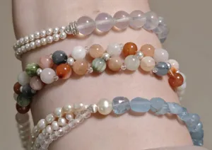 Detailaufnahme von bunten Kristall-, Perlen- und Edelstein-DIY-Perlenarmband am Handgelenk.