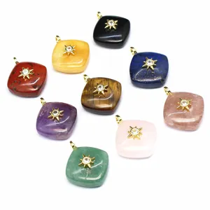 Close-up detail of assorted natural stone rhombus crystal pendants featuring a gold sun charm.