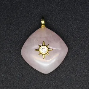 Detailed close-up shot of the rose quartz rhombus pendant featuring a gold starburst design.