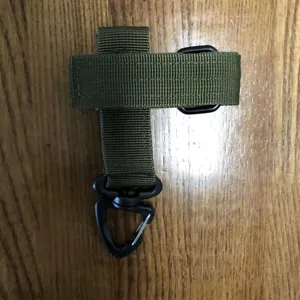 Vista dettagliata del cinturino tattico per guanti in nylon verde resistente con ganci neri.