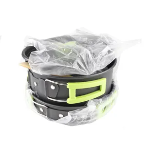 Closeup view of nested camping cookware set with green folding handles and protective wrap.