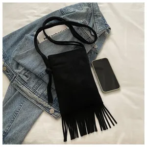 Detalle cercano del bolso movil con flecos negro, diseño minimalista con borlas elegantes.