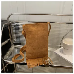 Vista detallada del bolso cruzado de ante marrón con flecos, bolso para el móvil.