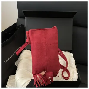 Vista detallada del bolso cruzado con flecos de ante rojo, minibolso de hombro estilo bohemio.