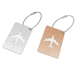 Vue détaillée d'étiquettes de bagage en aluminium évidé avec avion en argent et or rose.