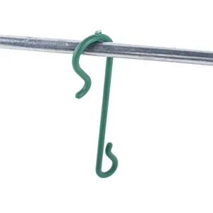 Gros plan d'un crochet de décoration de Noël en plastique vert accroché sur une tige en métal.