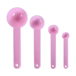 Detail view of pink plastic measuring spoons with clear capacity markings for baking.