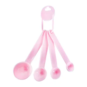 Detailed view of pink plastic measuring spoons set, highlighting clear scale markings.