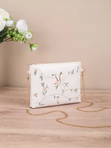 White floral embroidered shoulder crossbody bag with elegant butterfly detail and chain strap.