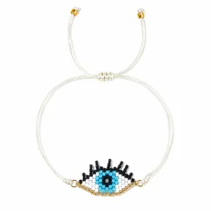 Handgemaakt geweven witte armband met blauwe boze oog kralen en verstelbaar ontwerp.