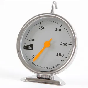 Stainless steel mechanical oven thermometer dial close up showing clear scale range.