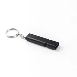 Sifflet de survie noir a double tube avec porte-cles, detail d'equipement outdoor EDC.