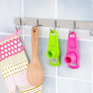 Mini garlic press and ginger grater tool for kitchen cooking, handy handheld manual mashing gadget.