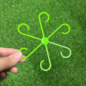 Vue de detail du support de tige de plante en plastique vert montrant sa conception a branches.