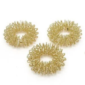 Nahaufnahme von goldenen Fingermassageringen, spitzige Metall Akupressurringe zur Entspannung.