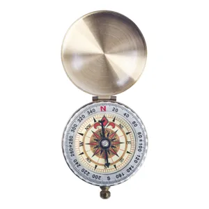 Detailed view of vintage brass pocket compass with open lid for outdoor hiking navigation