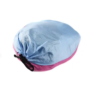 Portable parachute fabric outdoor hammock in compact storage bag for camping and travel.