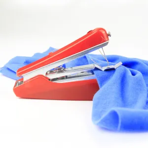 Portable handheld mini sewing machine detail shot for quick fabric repairs and sewing crafts.