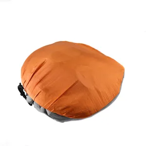Compact outdoor parachute hammock in compressed storage bag, orange and grey portable design.