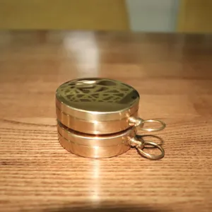 Detailed view of vintage copper pocket compass, showing fine metallic texture and hanging ring.