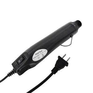 Close-up detail of the portable mini heat gun showing ergonomic black handle and power switch.