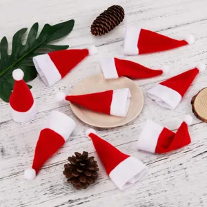 Détail de mini bonnets de Père Noël, étuis rouges et blancs pour couverts et bouteilles.