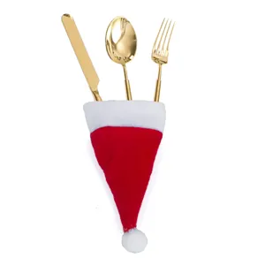 Ensemble de couverts en acier doré dans un mini bonnet de Noël mignon pour table festive.