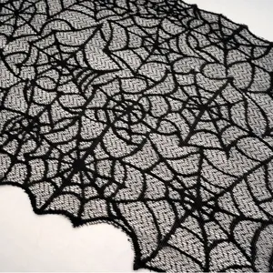 Dettaglio di tessuto in pizzo nero con ragnatela, runner gotico per feste di Halloween.