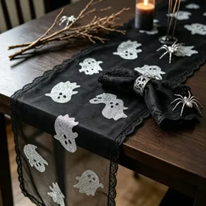 Black lace Halloween table runner featuring silver glitter ghost prints for festive decoration.