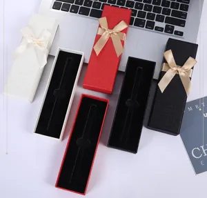 Elegantes cajas de regalo largas con lazos de cinta y interior de terciopelo para bolígrafos.