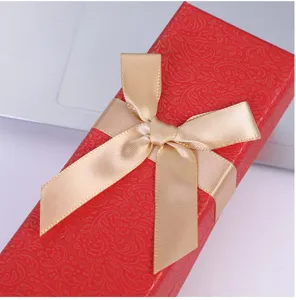 Caja de regalo roja para bolígrafo con lazo dorado, elegante envase para plumas.