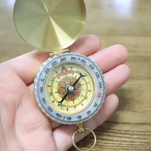Vintage brass pocket compass outdoor navigation tool with flip cover and scale dial.