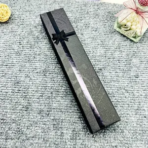 Long black gift box for jewelry necklace packaging with elegant ribbon and bow design.