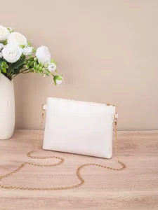 Close-up detail of the elegant white crossbody bag with luxury gold chain strap and smooth texture.